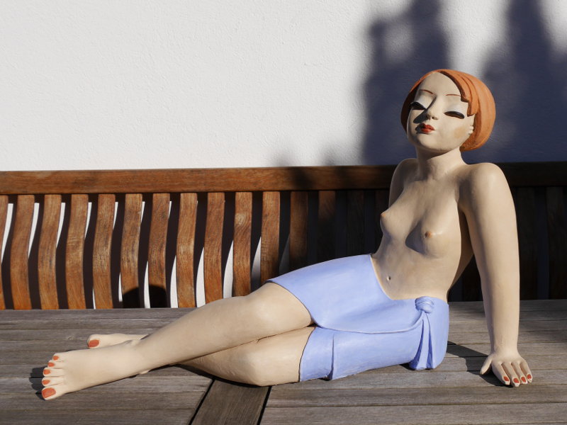 Gartenfigur Mädchen sitzend auf Tisch