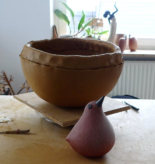 Großer Kunst Vogel vor kleinem Keramik Vogel Großer Kunst Vogel vor kleinem Keramik Vogel